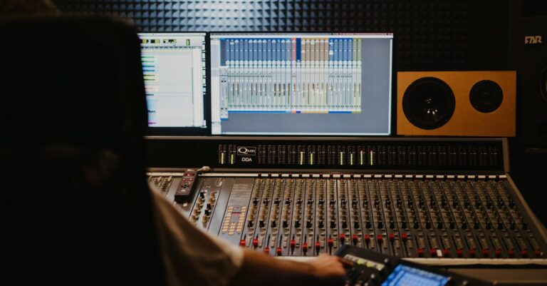 Close-up of a professional audio mixing console with sound engineer in a recording studio.